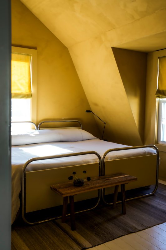 Bungalow bedroom featuring natural light, soft linens, and refined residential styling