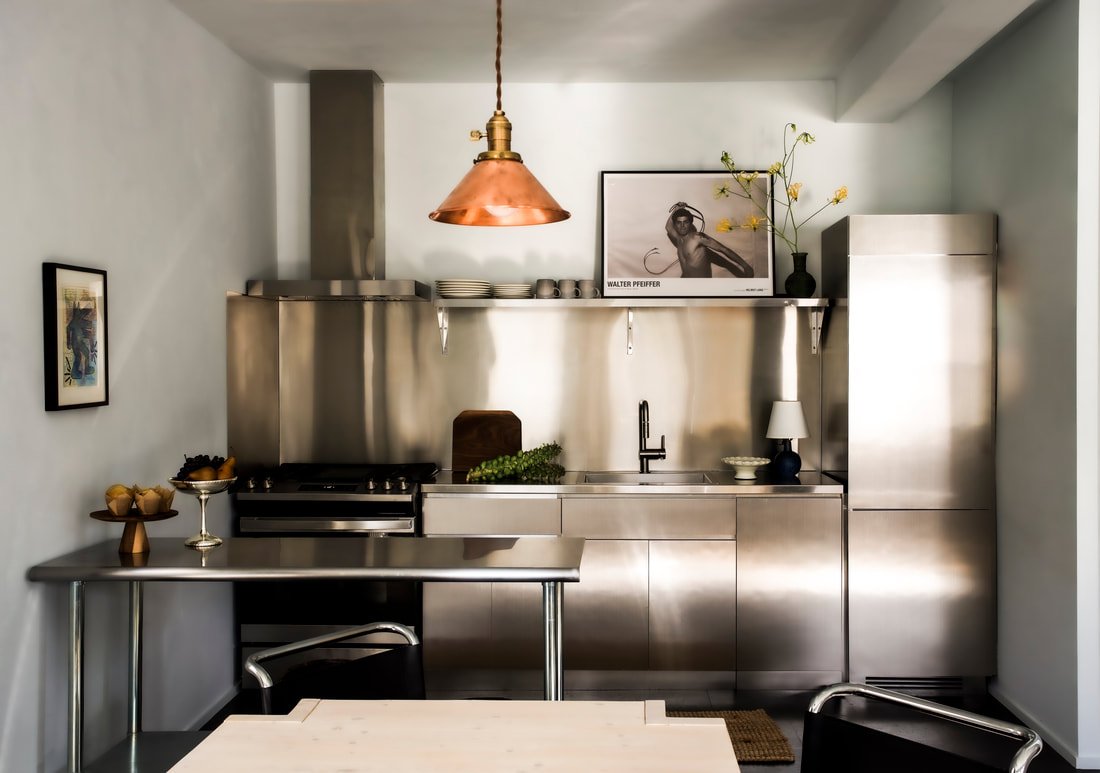 Bungalow kitchen with full appliances, open shelving, and refined coastal detailing for extended stays